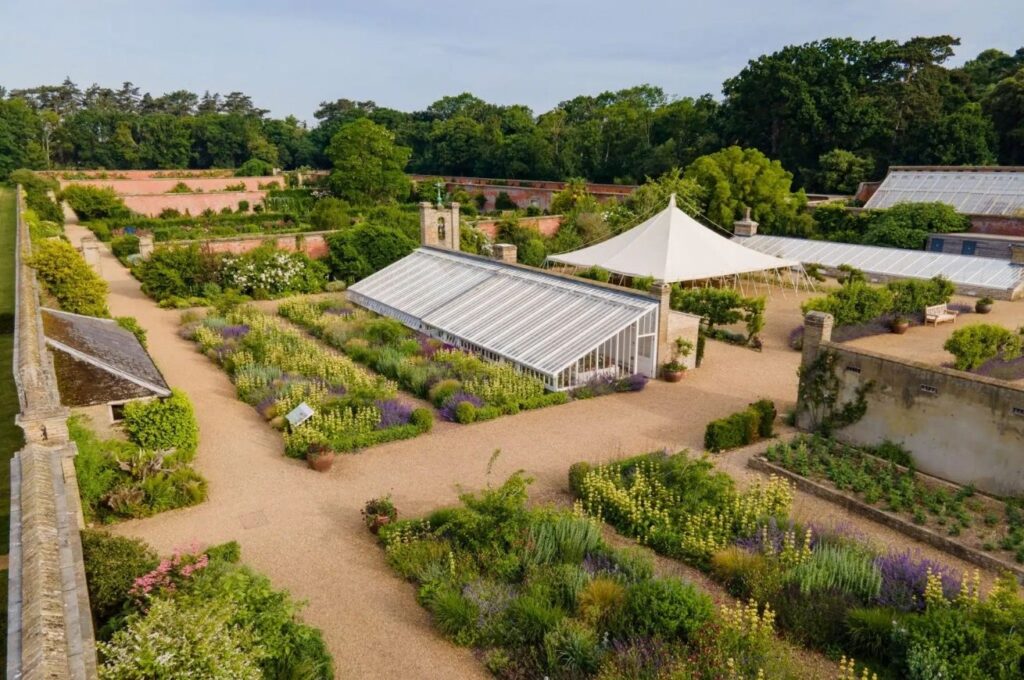 Aerial photo of Holkham Walled Garden in the summer with glass houses and a marquee