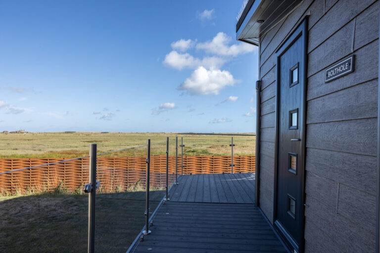 A static caravan named 'Bolthole' with a view over Brancaster marshes