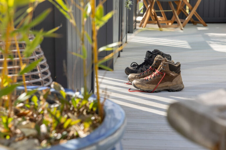 Two pairs of walking boots on some decking of a caravan holiday home