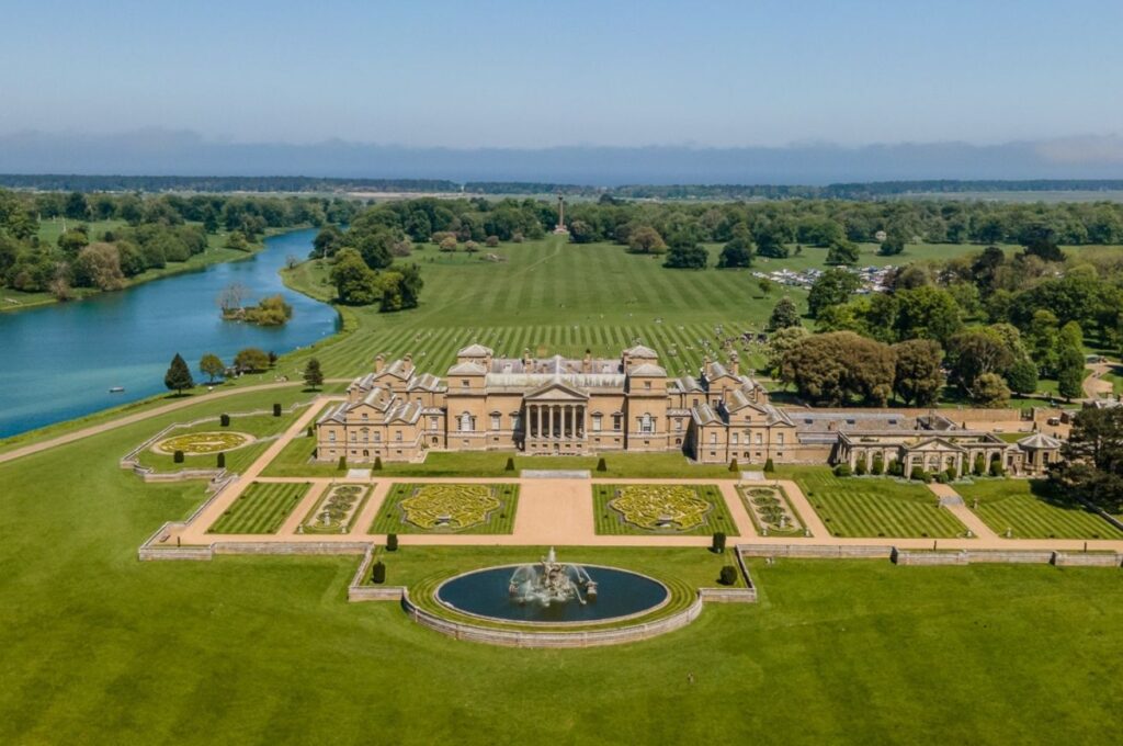 Aerial photo of Palladian Holkham Hall, Holkham Lake, the parkland and the sea in the distance