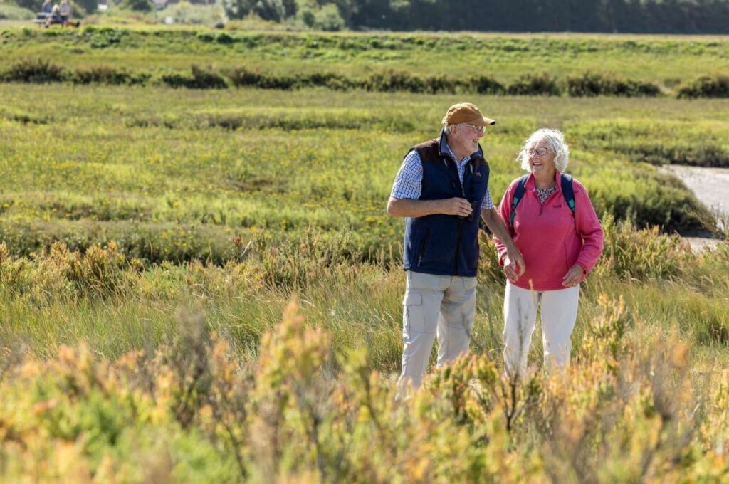 An older couple laugh on a sunny day at Thornham marshes