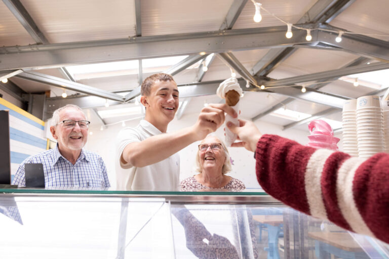 A teenage boy is served an ice cream