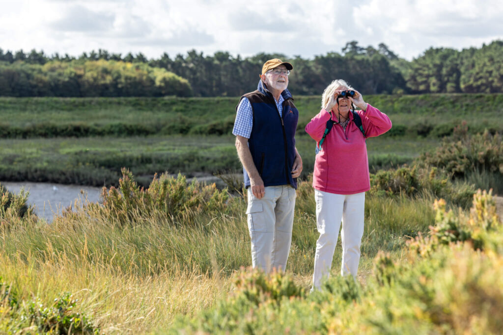 A retired couple birdwatching at Thornham Marshes