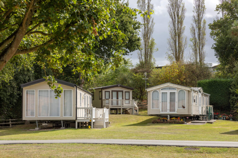 Static caravans on a field surrounded by trees