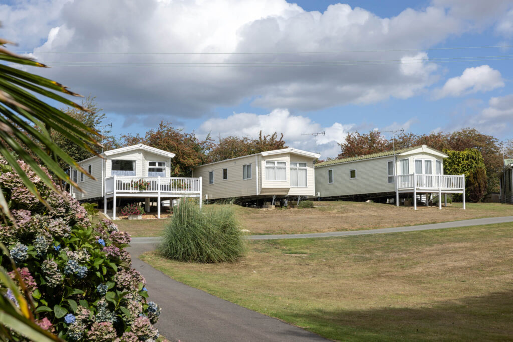 Three static caravans on a caravan park with neatly mown grass