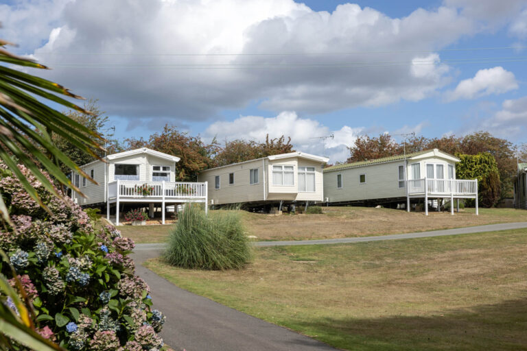Three static caravans on a caravan park with neatly mown grass