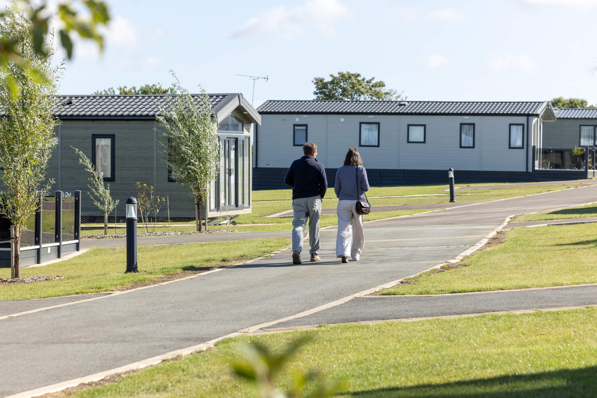 A man and woman walk down a path at a caravan park