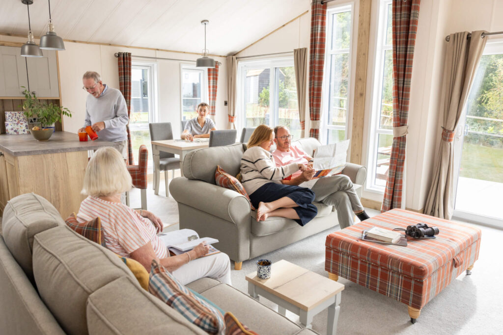 A family sit and chat on sofas in a modern lodge