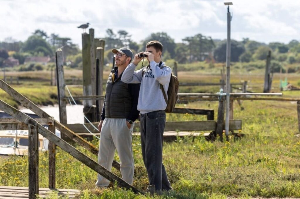 A dad and son bird watching on marshes