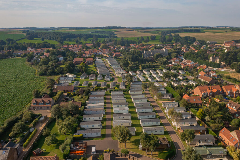 Drone photo of a smart looking caravan park by a village and fields