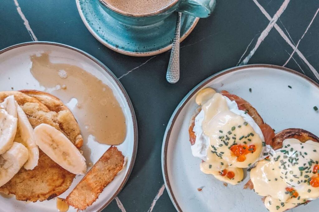 Pancakes and banana and eggs benedict from above