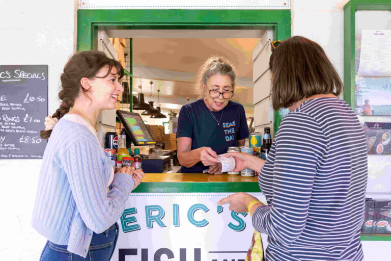 Two women placing a food order through a hatch
